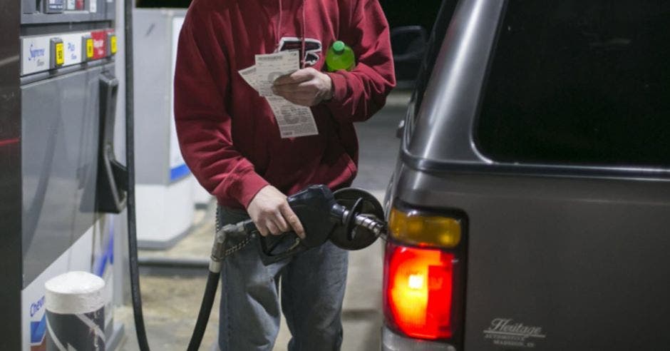 Un hombre llenando el tanque de combustible