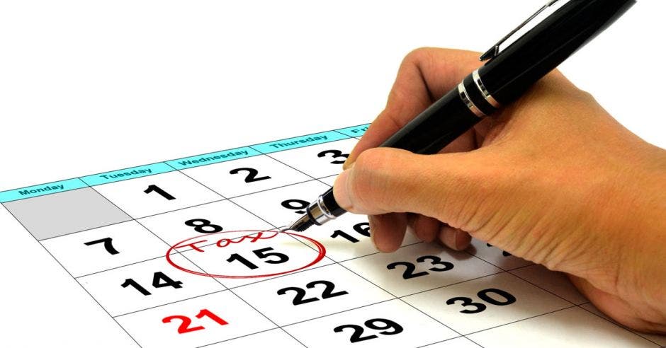 Persona con bolígrafo marca calendario