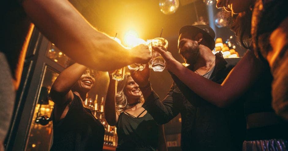 un grupo de amigos disfruta de bebidas alcohólicas en un bar