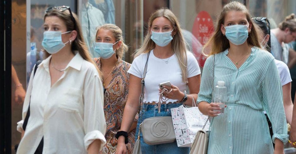 chicas de compras en la calle Kalverstraat, centro de la ciudad de Ámsterdam, con una mascarilla relacionada con el brote de Covid 19 / coronavirus