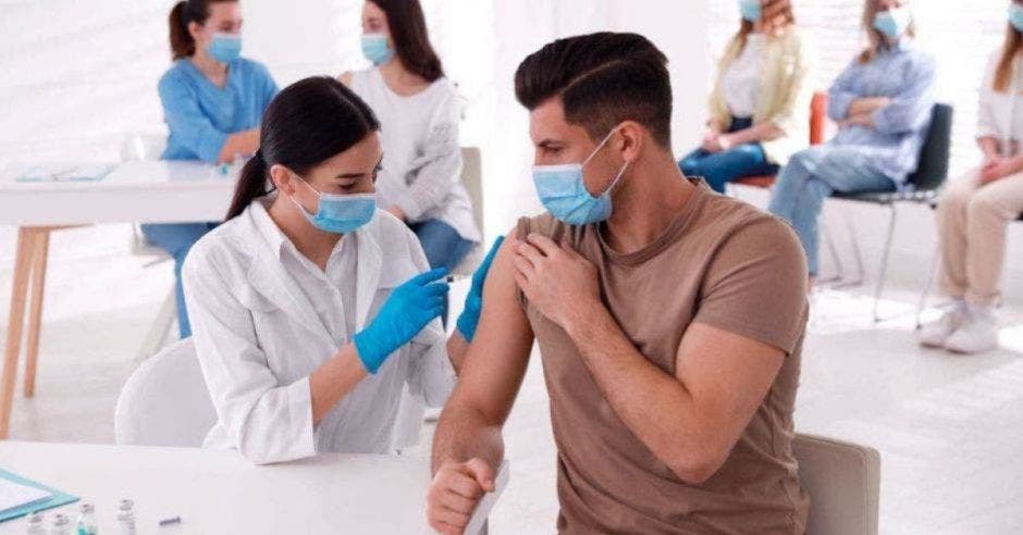 doctora vacunando contra la Covid a hombre joven