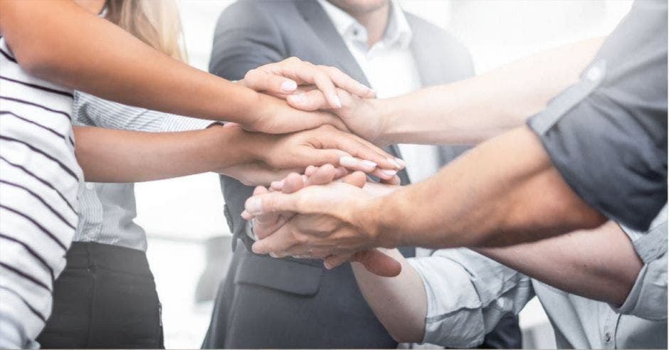 Varias personas formando una torre con sus propias manos